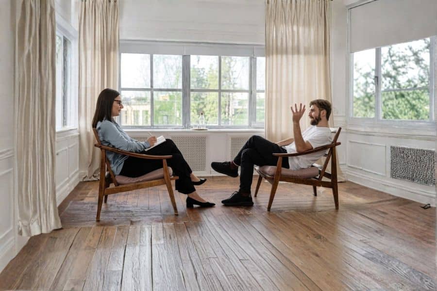 Sesión de coaching: una coach y su cliente conversan sentados frente a frente en una sala luminosa