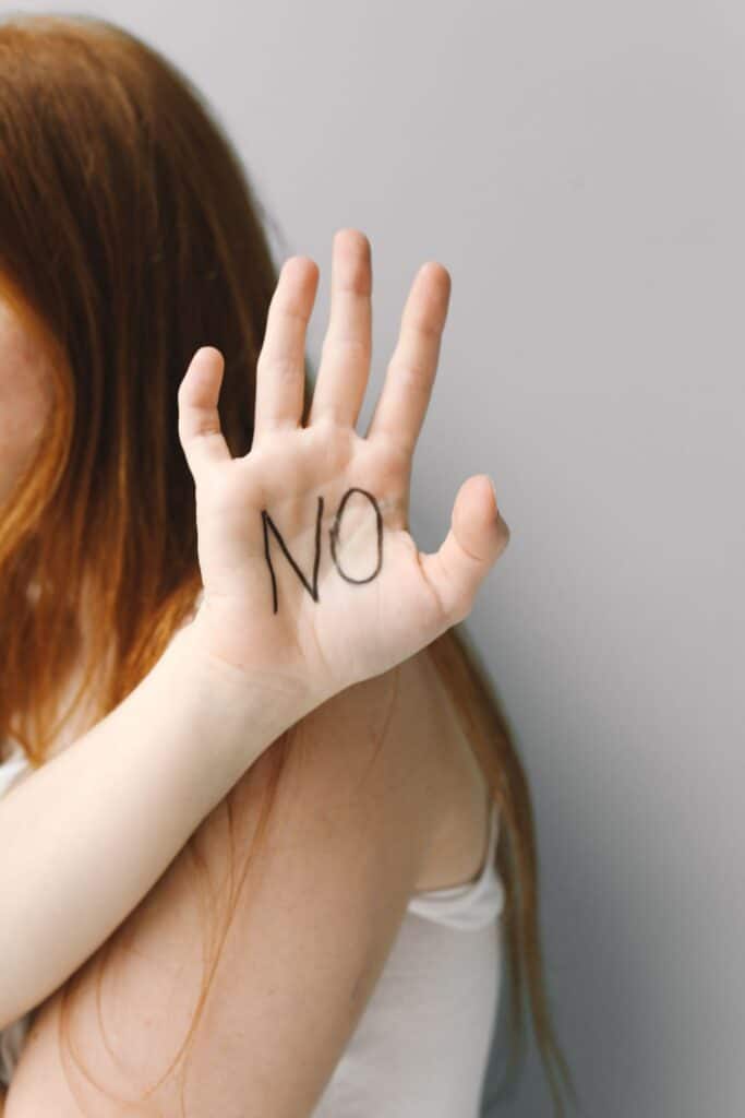 Mujer haciendo un gesto de límite con la mano, aprendiendo a decir que no
